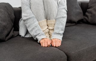 Cropped Shot Freezed Woman Warm Clothes Sitting Couch Warming Her — Stock Photo Cropped shot of freezed woman in warm clothes sitting on couch and warming her feet