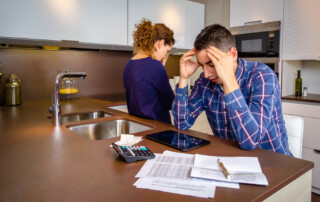 Desperate young couple with many debts reviewing their bills. Financial family problems concept.