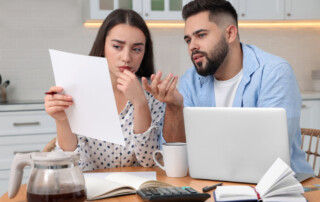 Young couple discussing family budget in kitchen